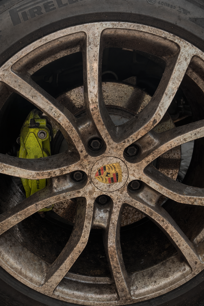 Alloy wheel coated in baked-on brake dust before cleaning