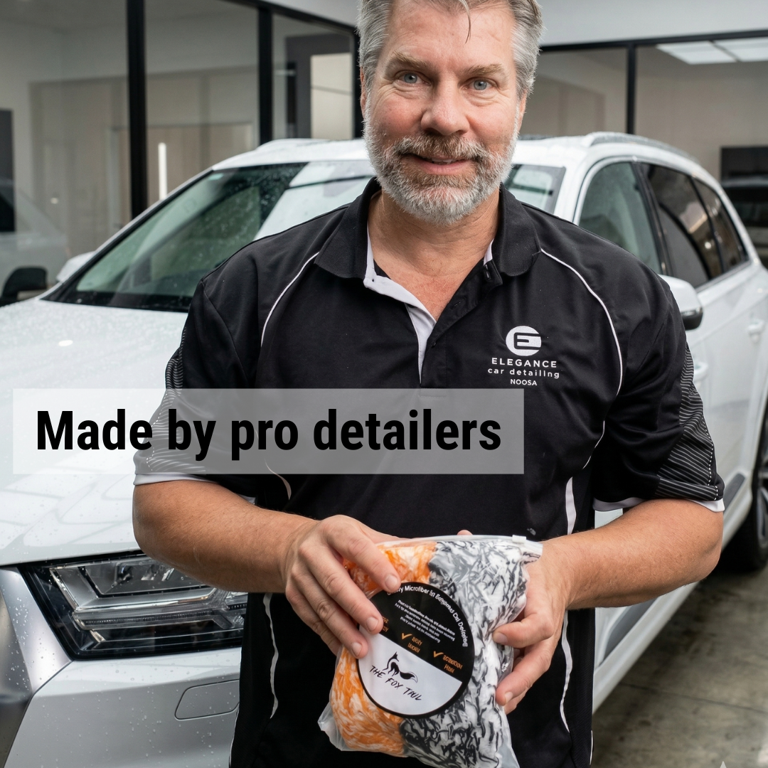 Man holding a product with text 'Made by pro detailers' in front of a white car.